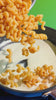 Video of Cavatappi noodles being prepared in a pot with peas and served on a white dish