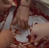 Hands scooping tomato sauce 
